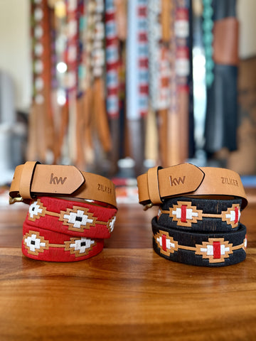 Two sets of woven bracelets with leather straps on a wooden surface, with a blurred background of more bracelets.