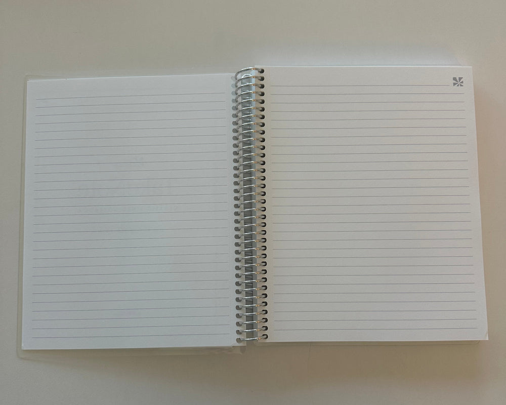 White notebook with lined pages on a beige background