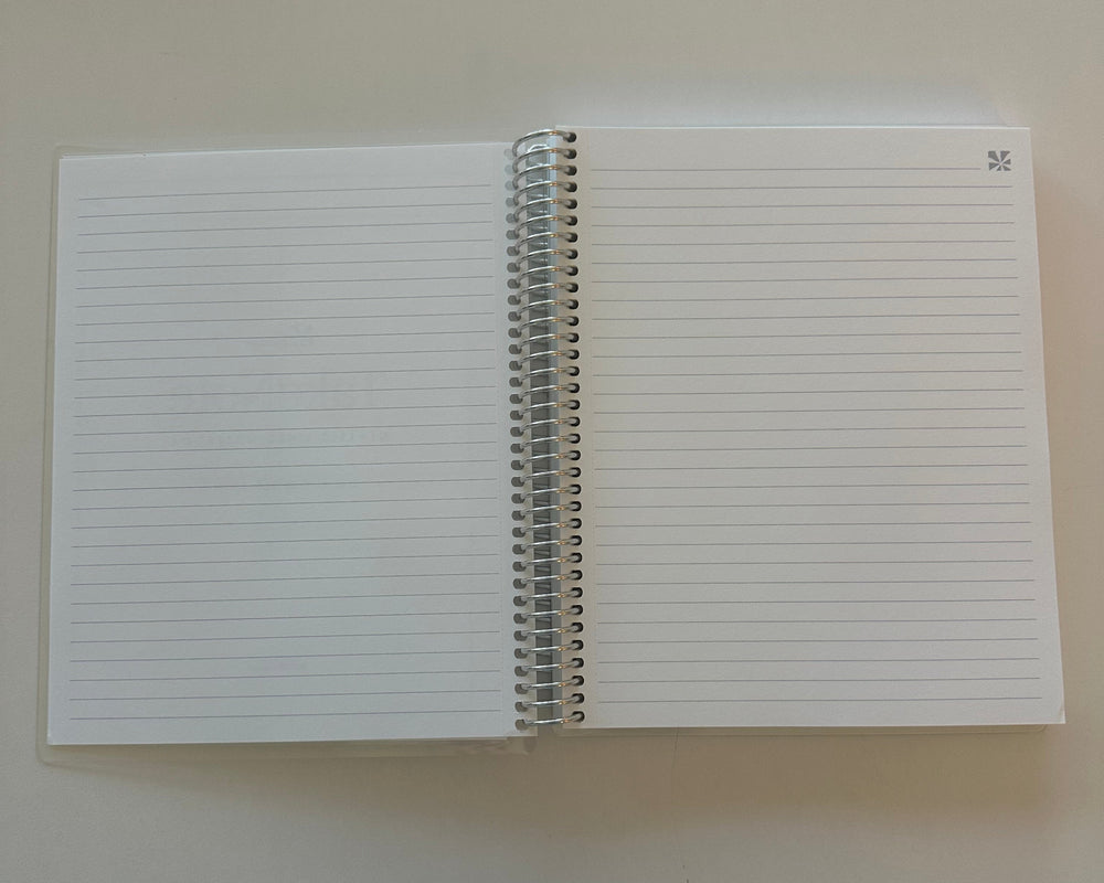 White notebook with lined pages on a beige background