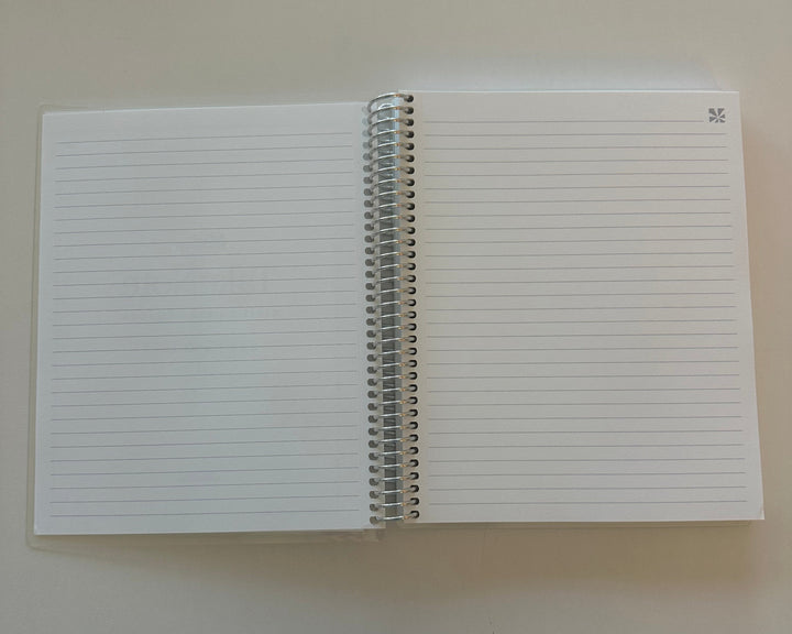White notebook with lined pages on a beige background