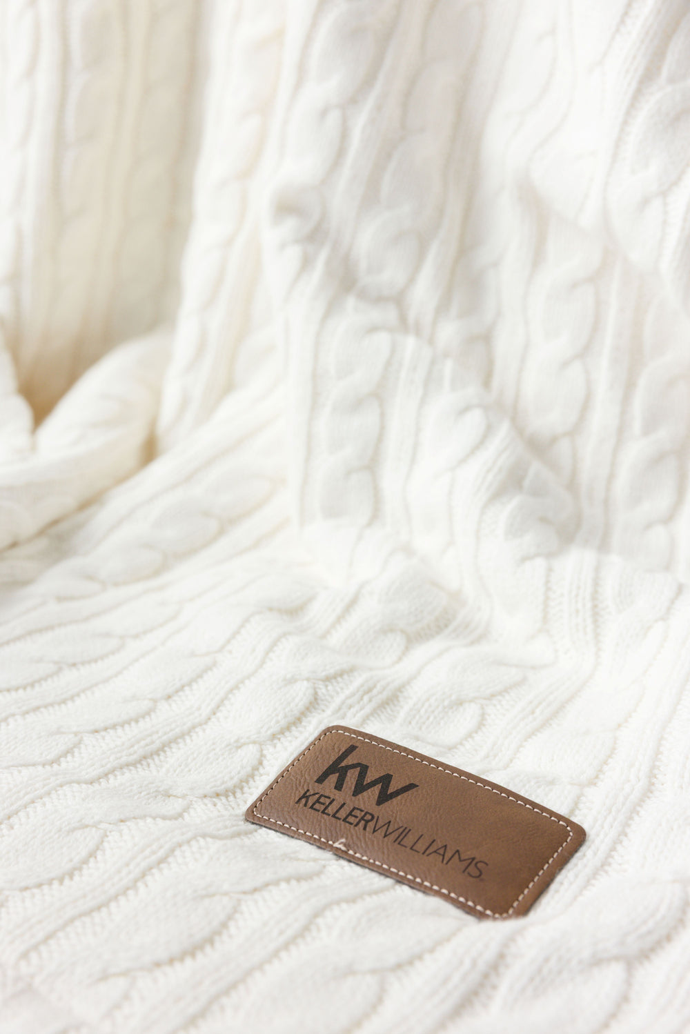 White textured blanket with a Keller Williams logo tag.