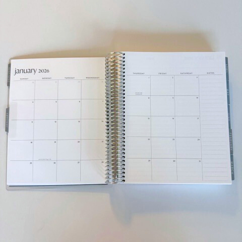 Open spiral-bound calendar showing January 2023 on a white background