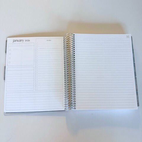 Open spiral-bound planner on a white surface