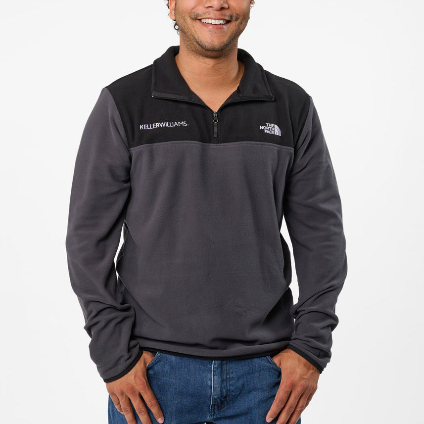 Man wearing a gray pullover with visible branding on a white background