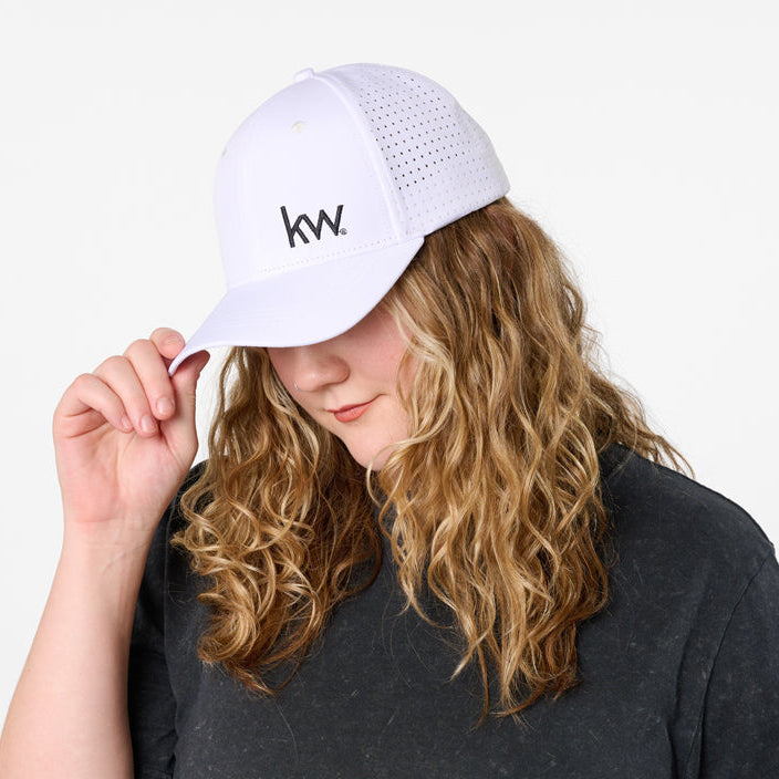 Person wearing a black t-shirt with a white cap featuring a KW logo.