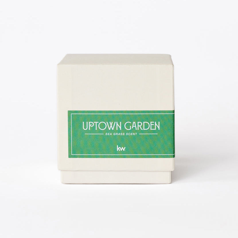 Candle with 'Uptown Garden' label on a white background