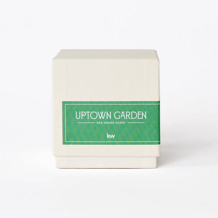 Candle with 'Uptown Garden' label on a white background